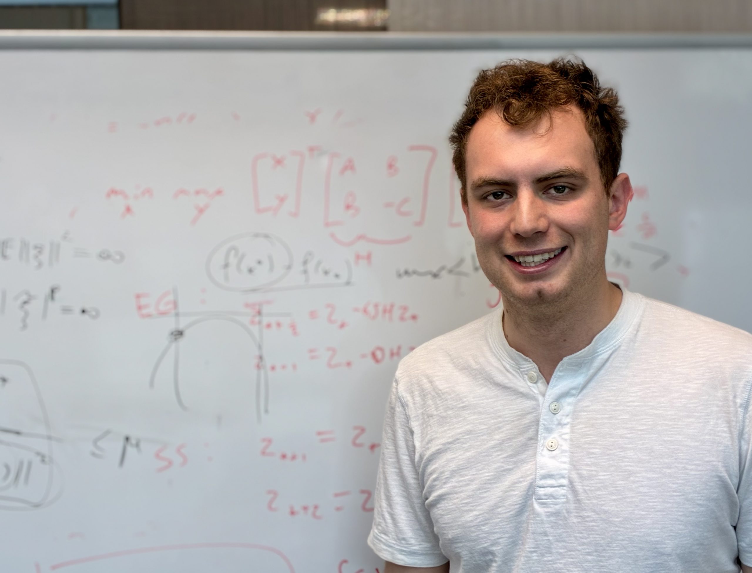 Researcher standing in front of a white board with functions